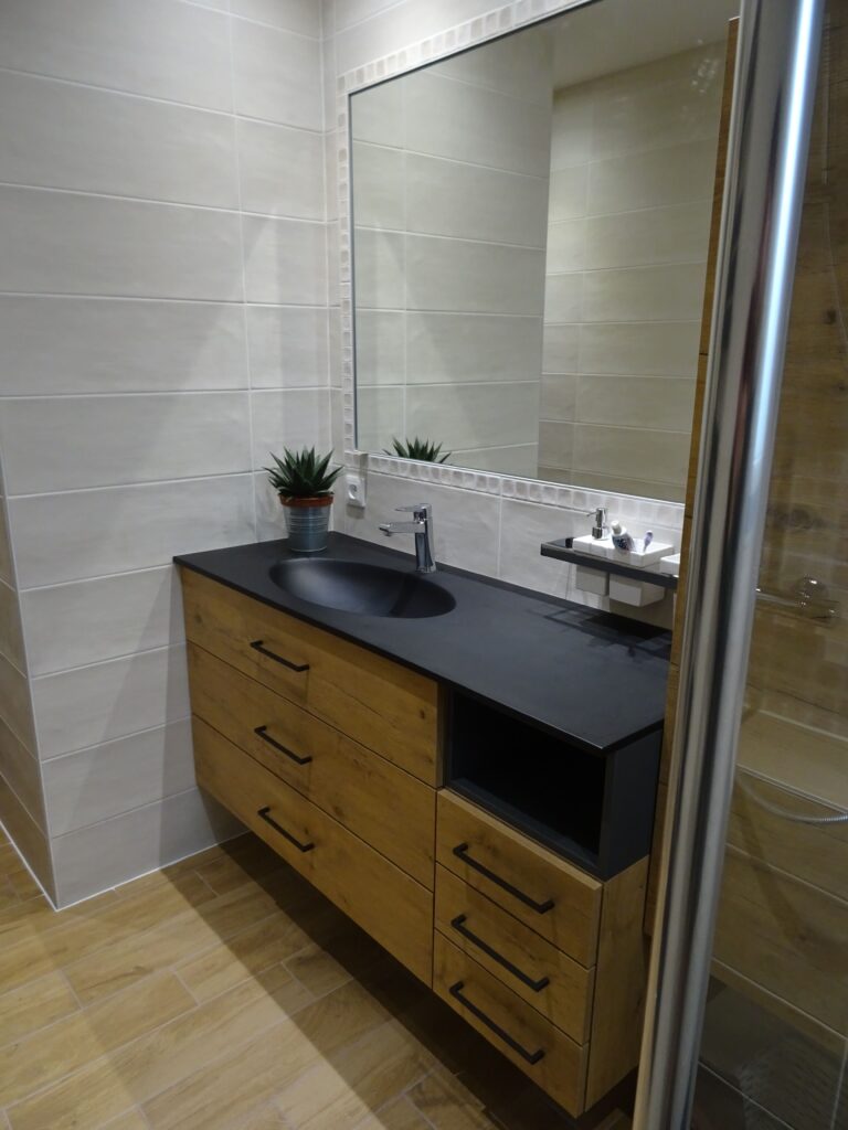 Une salle de bain avec combinaison de bois et vasque noir